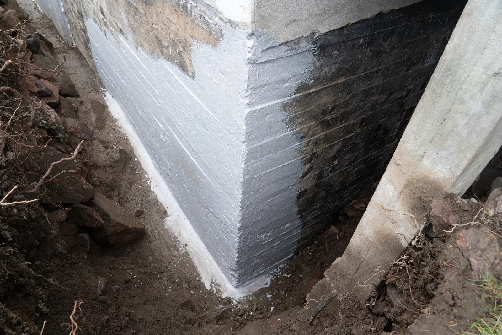 Excavated foundation wall with waterproof membrane applied by Promaster Maintenance Corp, Long Island, NY