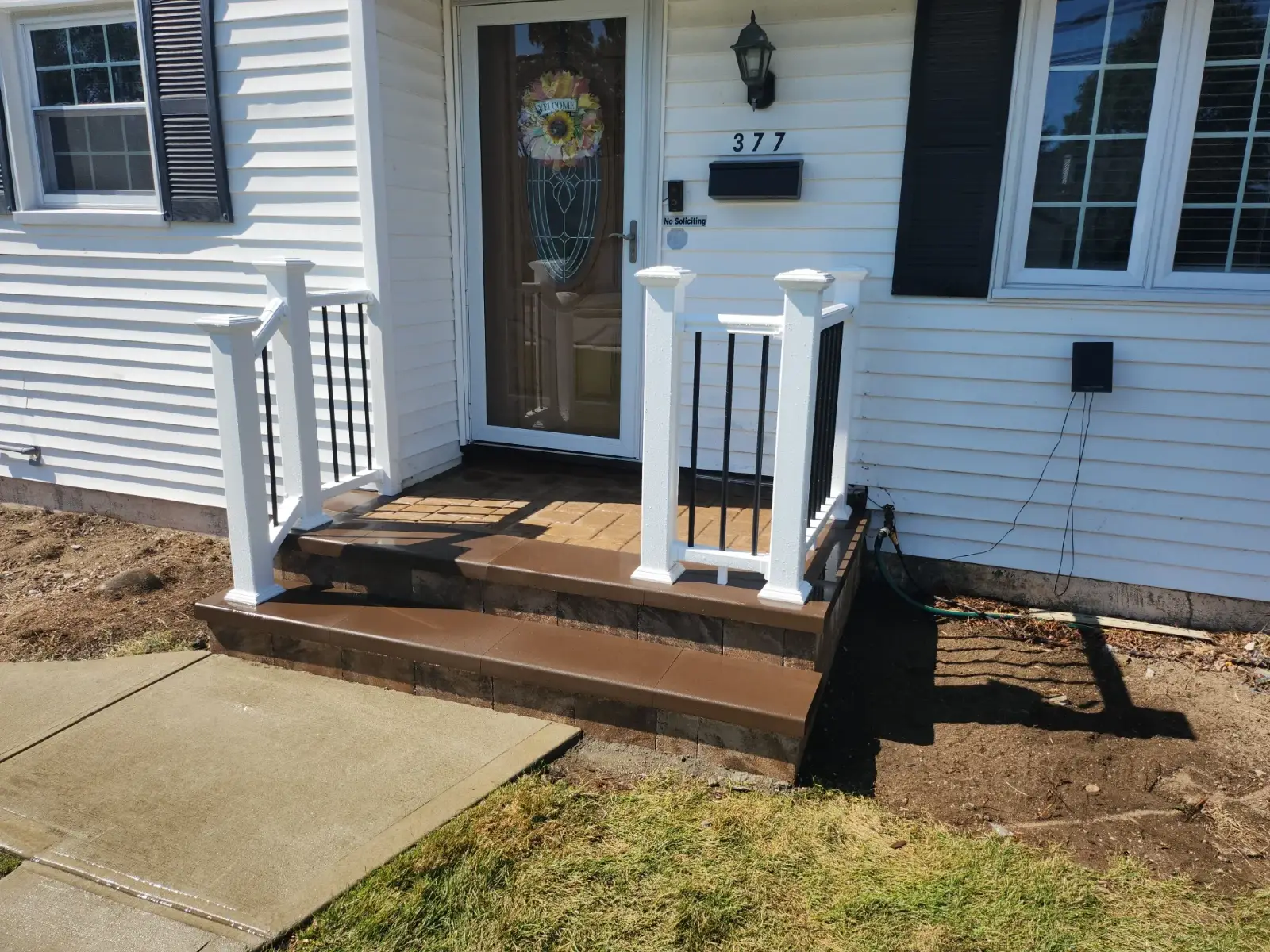 Paver stoop with brown caps and railings by Promaster Maintenance Corp, Long Island, NY