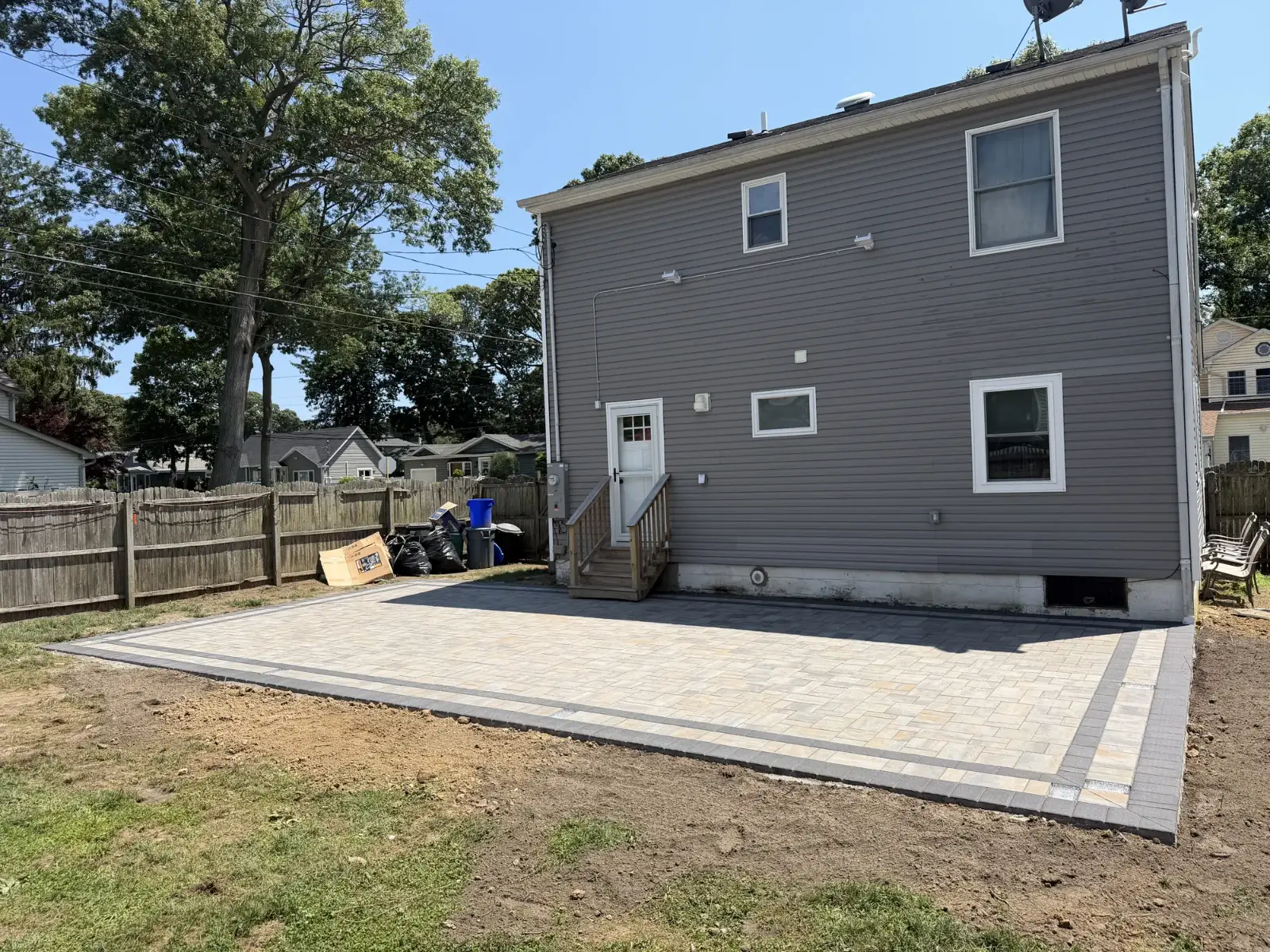 Backyard patio with contrast border by Promaster Maintenance Corp, Long Island, NY