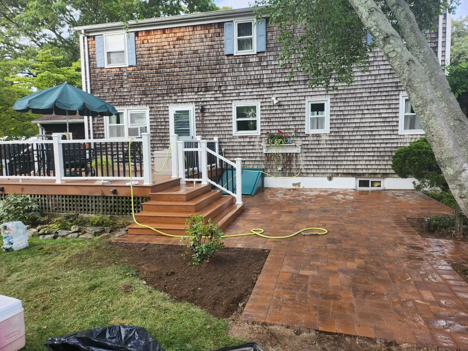 Paver patio beside deck steps by Promaster Maintenance Corp, Long Island, NY