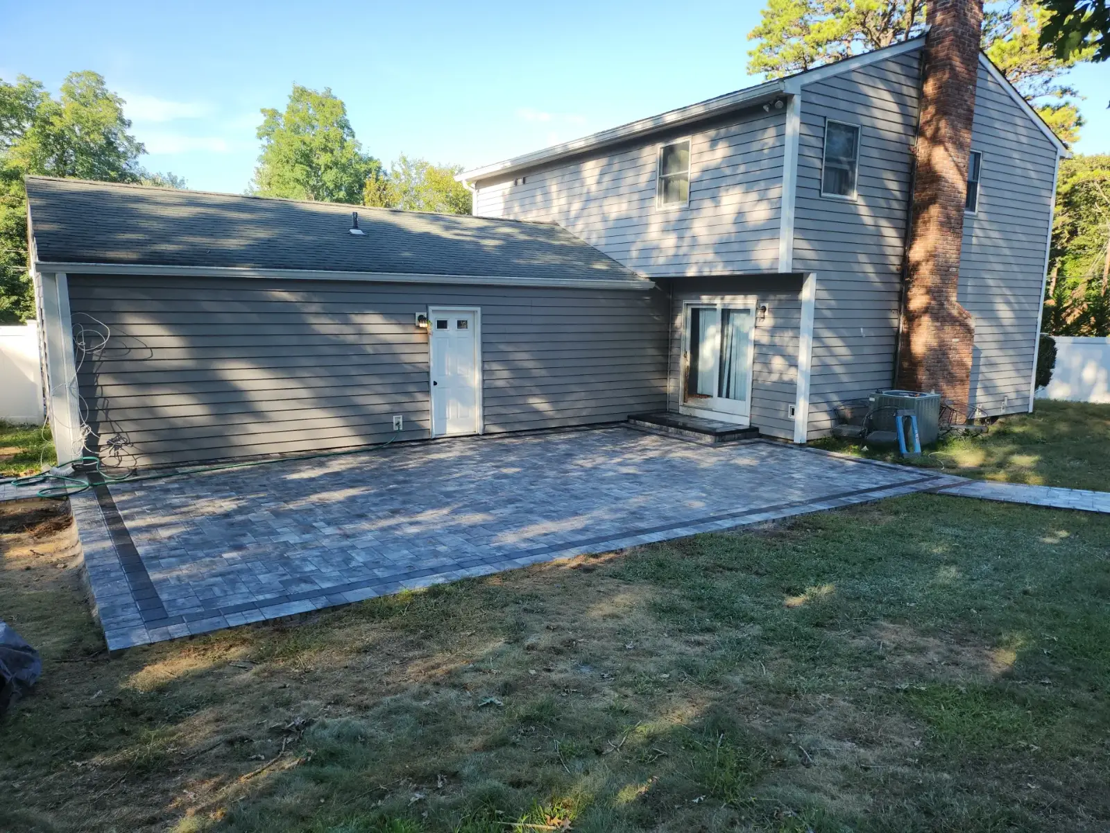 Paver patio with charcoal border by Promaster Maintenance Corp, Long Island, NY