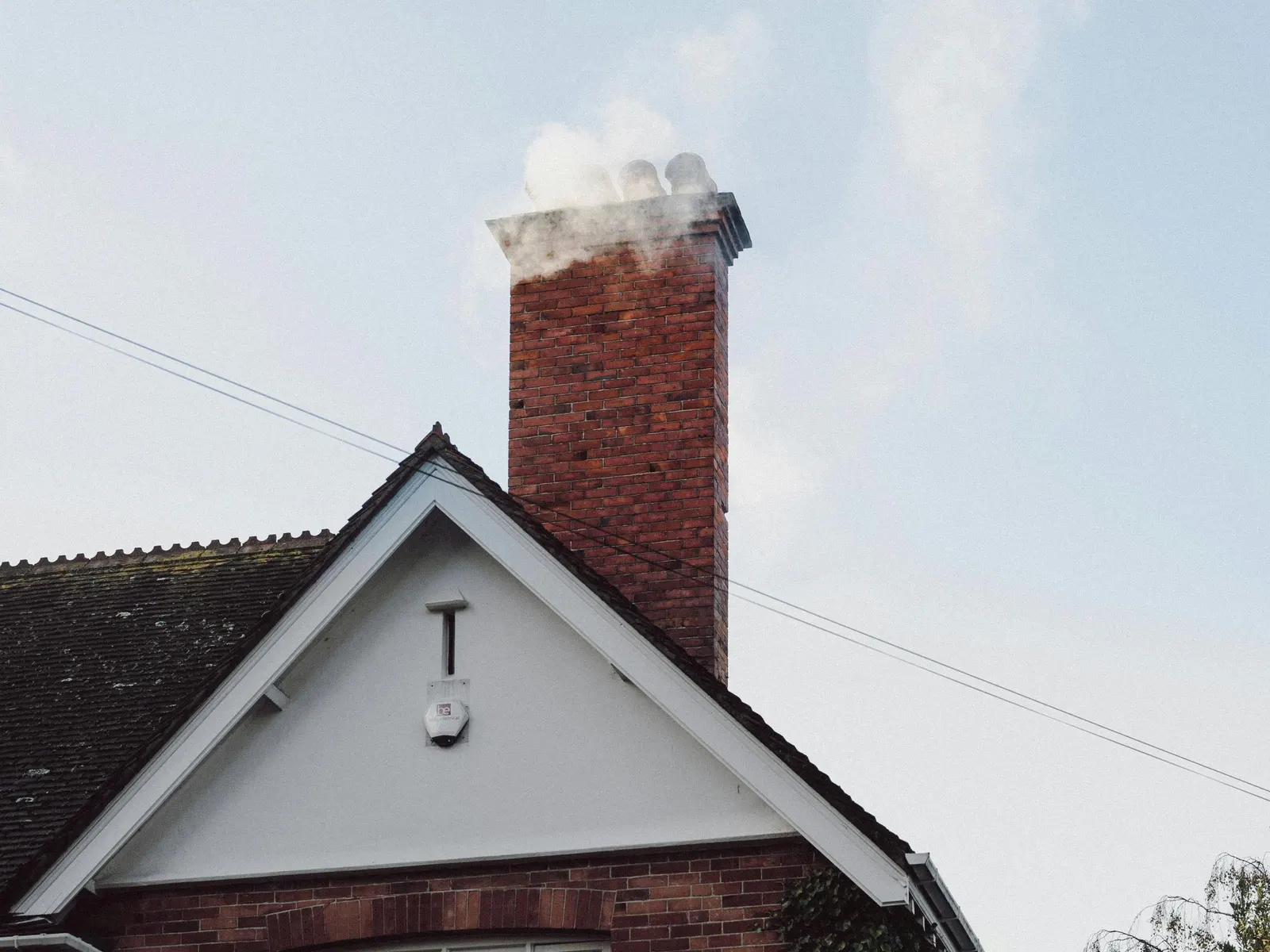 Brick chimney with smoke from a lit fireplace